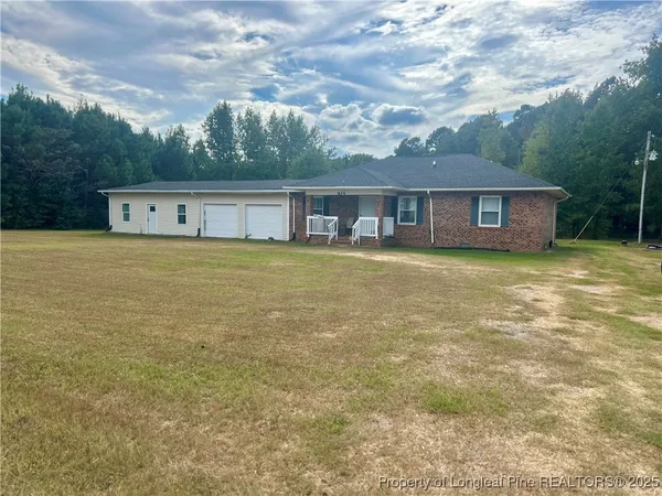 a front view of house with yard and trees