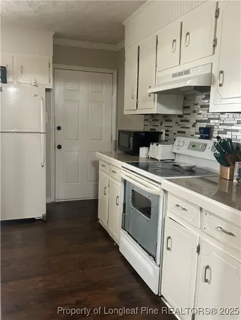 a kitchen with white cabinets and white appliances