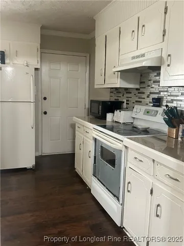 a kitchen with white cabinets and white appliances