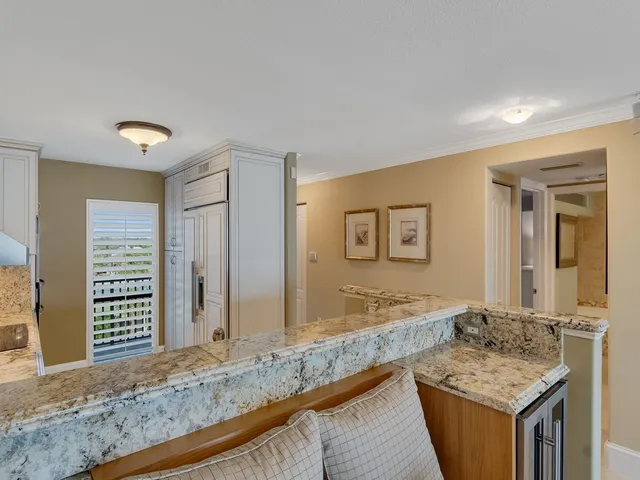 a kitchen with granite countertop white cabinets and stainless steel appliances