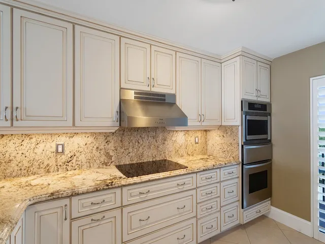 a kitchen with granite countertop a sink and a stove