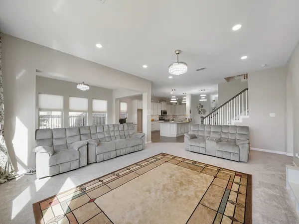 a living room with furniture large windows and wooden floor