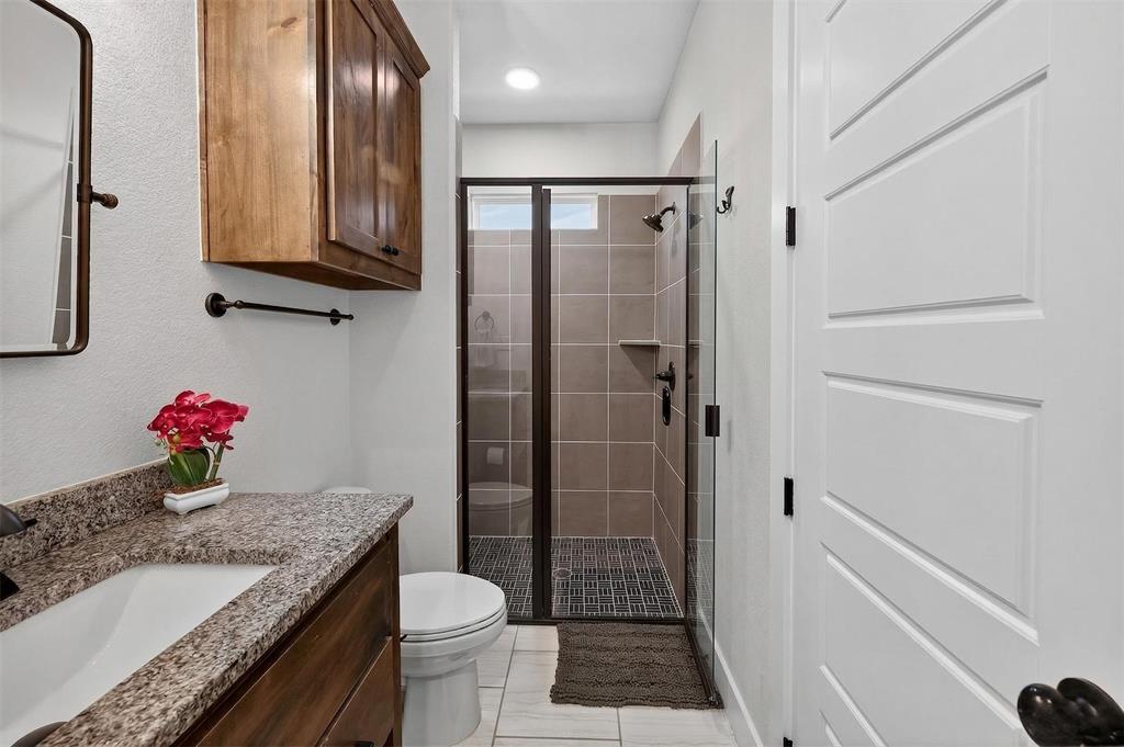 221 Proctor Lane Decatur, TX 76234 - Photo 17 of 30 a bathroom with a granite countertop sink toilet and shower