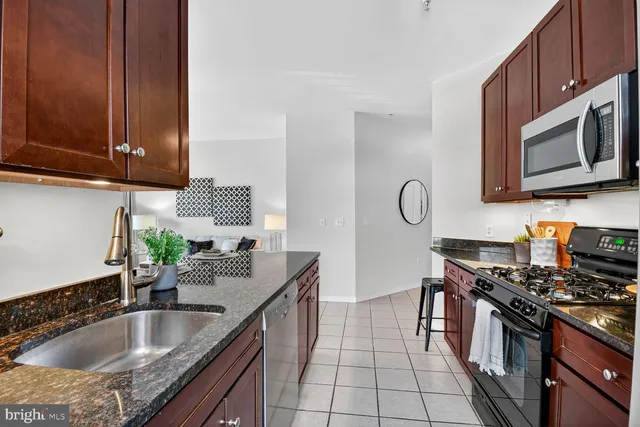 a kitchen with stainless steel appliances granite countertop a sink stove and microwave