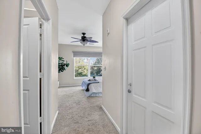 a view of a hallway with wooden floor and a livingroom