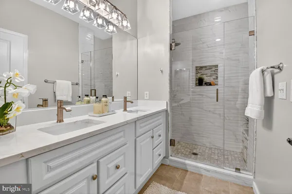 a bathroom with a double vanity sink mirror and shower