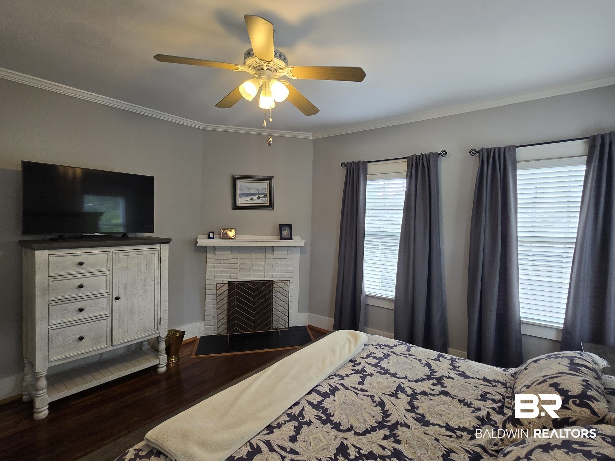 54 South Catherine Street Mobile, AL 36604 - Photo 33 of 55 Bedroom featuring wood finished floors, ornamental molding, a brick fireplace, a ceiling fan, and baseboards