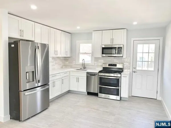 a kitchen with cabinets stainless steel appliances and window