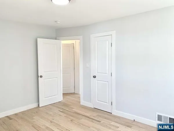 an empty room with wooden floor and closet