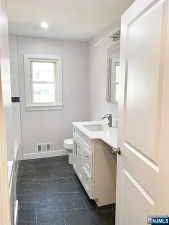 a bathroom with a sink a toilet and a mirror