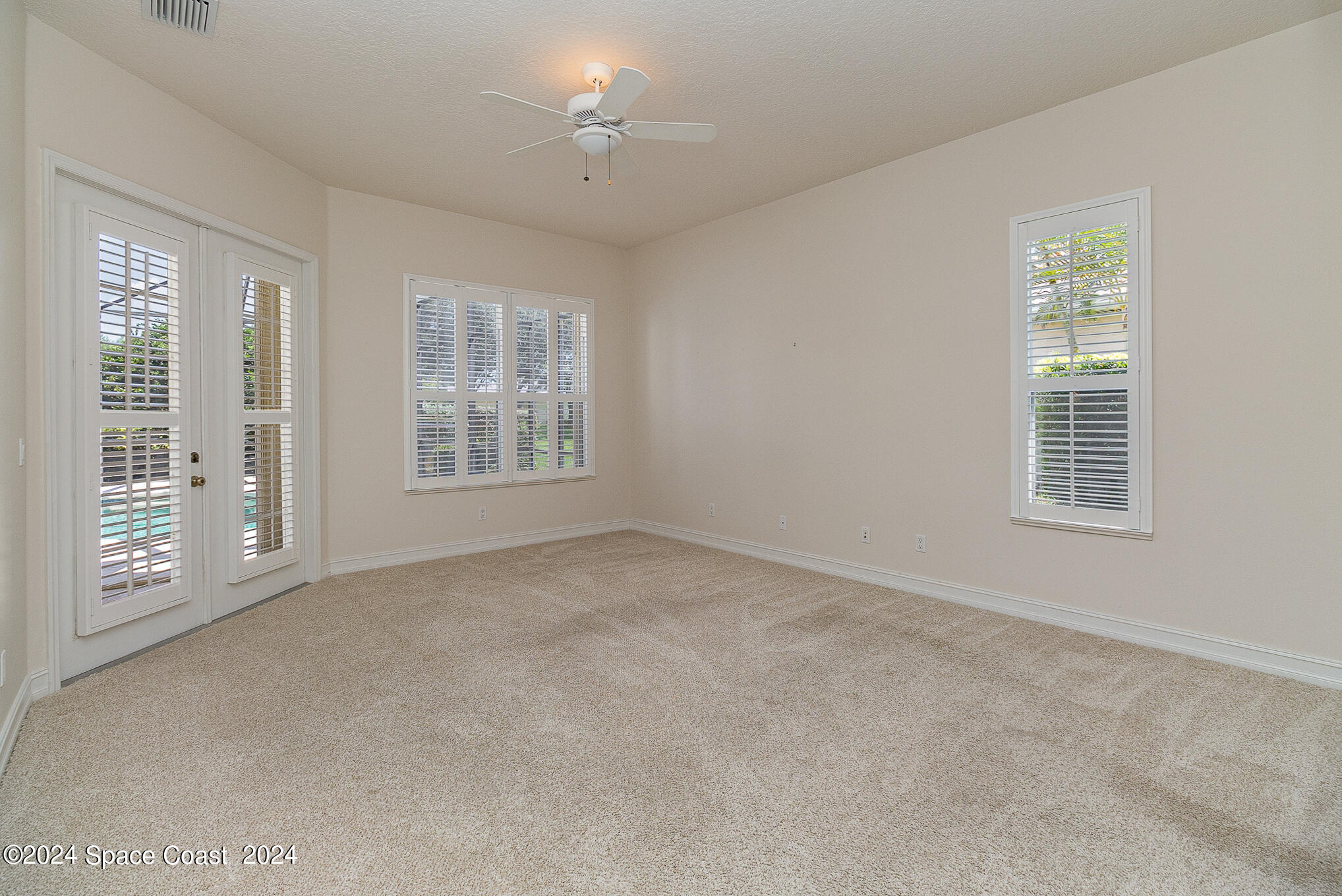 465 Baytree Drive Melbourne, FL 32940 - Photo 18 of 36 an empty room with windows chandelier fan and windows