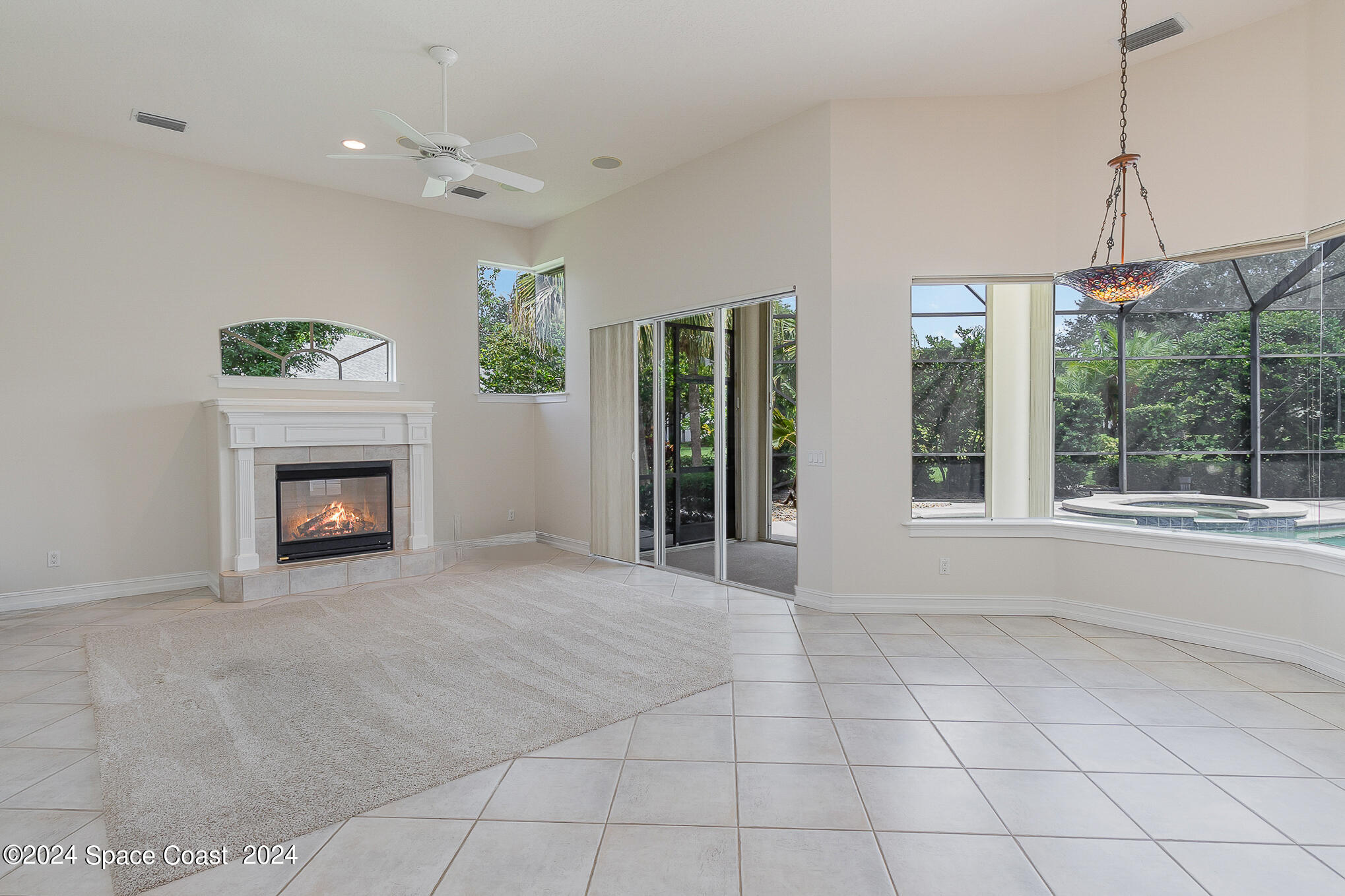 465 Baytree Drive Melbourne, FL 32940 - Photo 10 of 36 a view of an empty room with a fireplace and a window