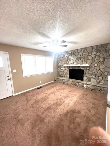 an empty room with windows and fireplace