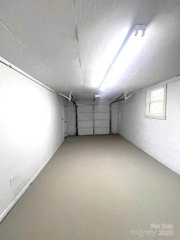 an empty room with a fireplace and windows