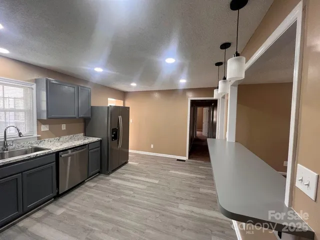 a kitchen with stainless steel appliances granite countertop a refrigerator and a sink