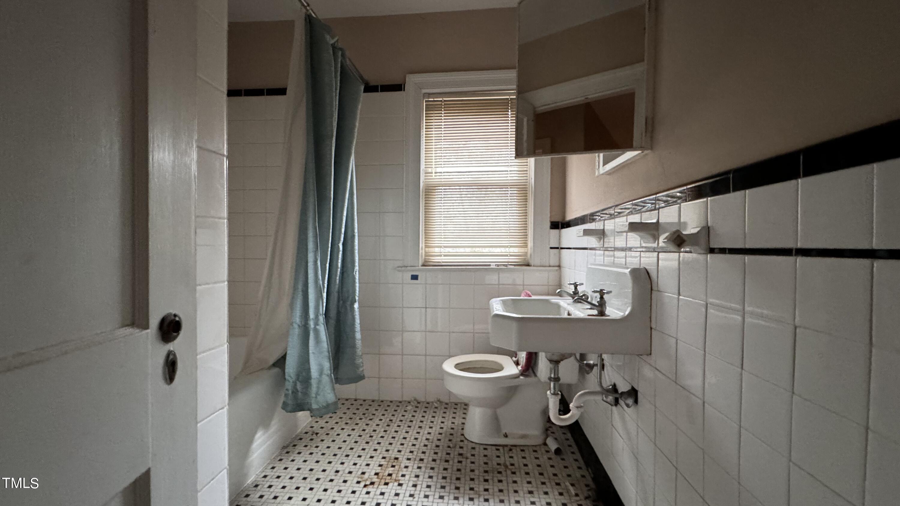 116 Horne Street Raleigh, NC 27607 - Photo 4 of 16 a bathroom with a sink a toilet a window and shower