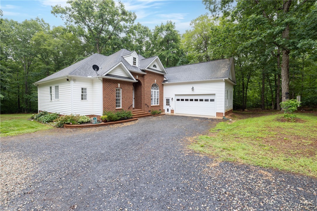 a view of a house with a yard and large trees