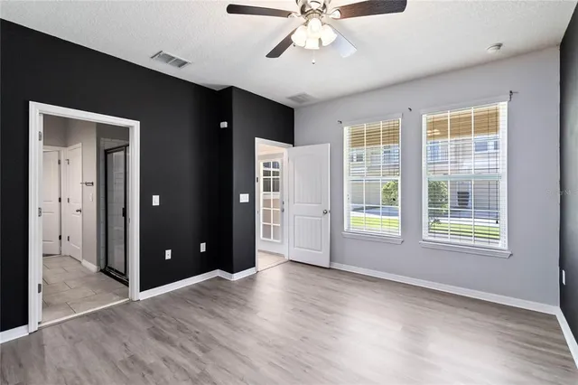 a view of an empty room with a window and wooden floor