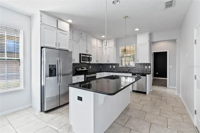 a kitchen with a refrigerator a sink a stove a microwave and island