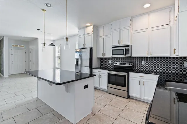 a kitchen with stainless steel appliances a refrigerator sink and microwave