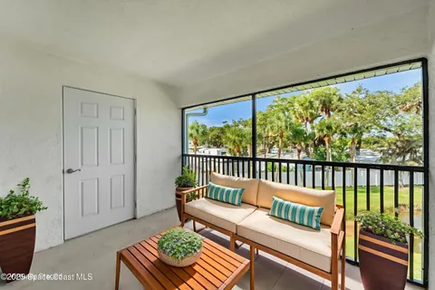 a balcony with furniture and a potted plant