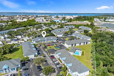 an aerial view of residential houses with outdoor space and trees