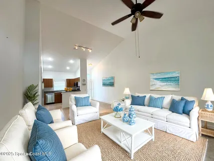 a living room with furniture and a view of kitchen