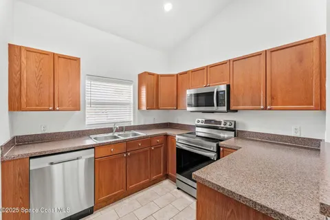 a kitchen with stainless steel appliances granite countertop a sink stove and microwave