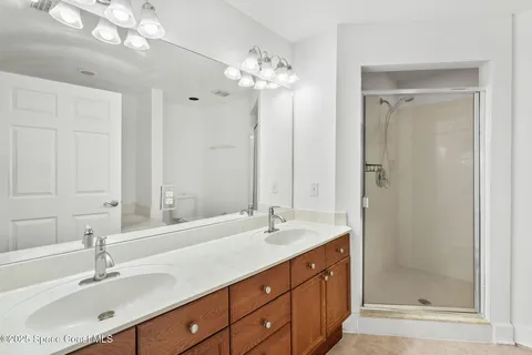 a bathroom with a double vanity sink mirror and shower