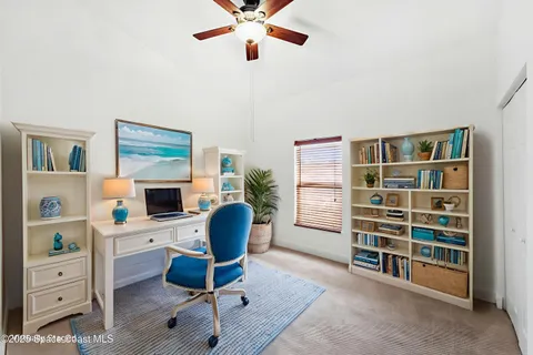 a view of a workspace with furniture and a window