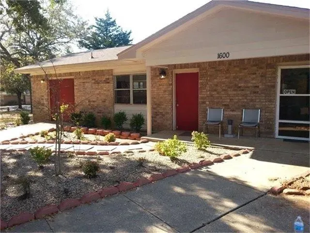 a backyard of a house with large tree and wooden fence