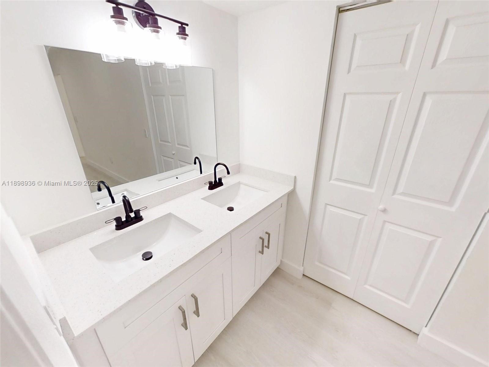 20230 Northeast 3rd Court, Unit 6 Miami, FL 33179 - Photo 14 of 44 a bathroom with a sink and a mirror