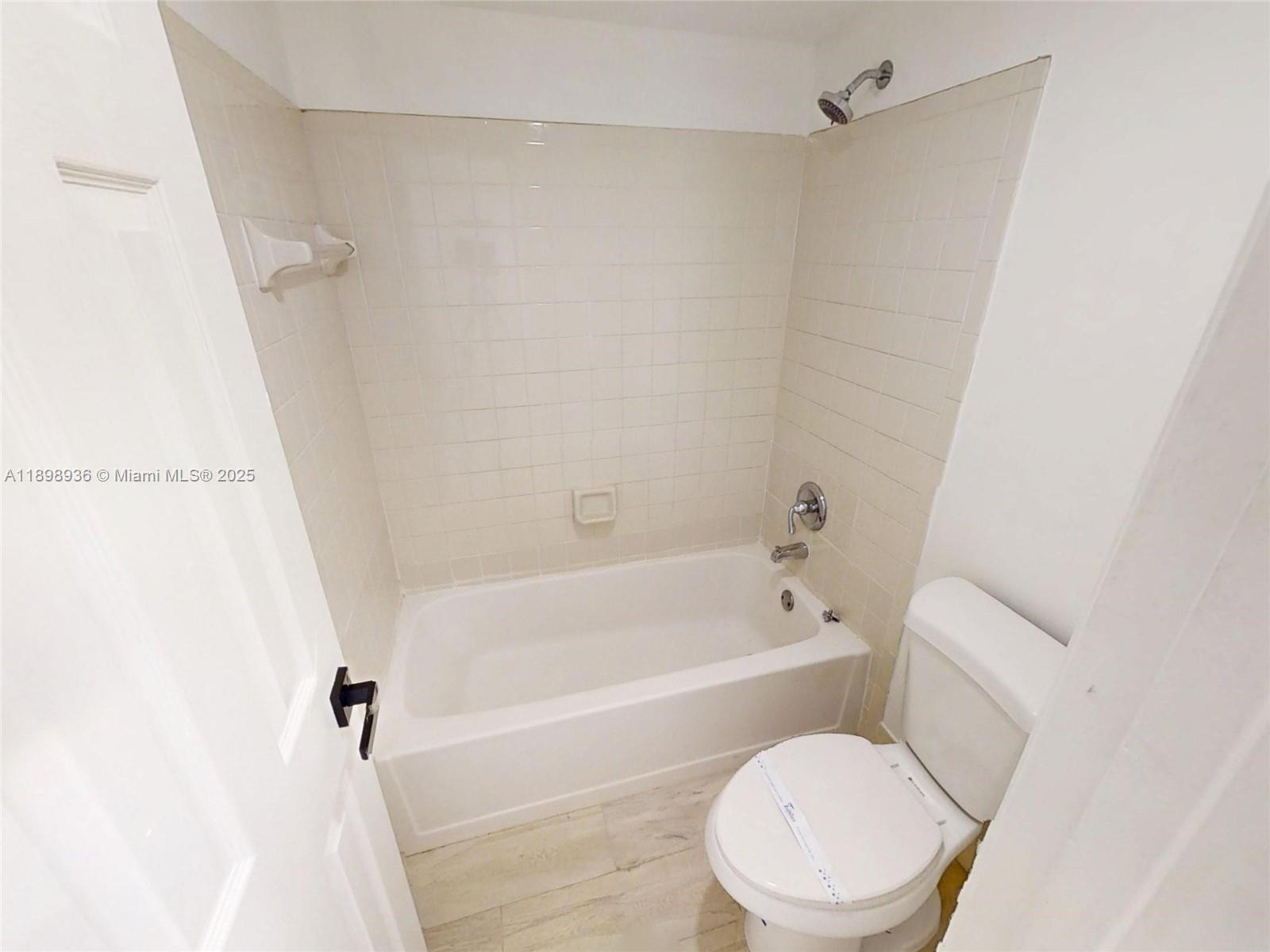 20230 Northeast 3rd Court, Unit 6 Miami, FL 33179 - Photo 16 of 44 a white toilet sitting next to a bath tub