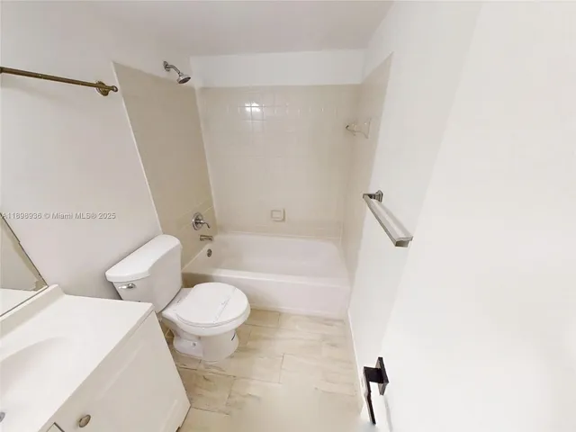 a white toilet sitting next to a bath tub