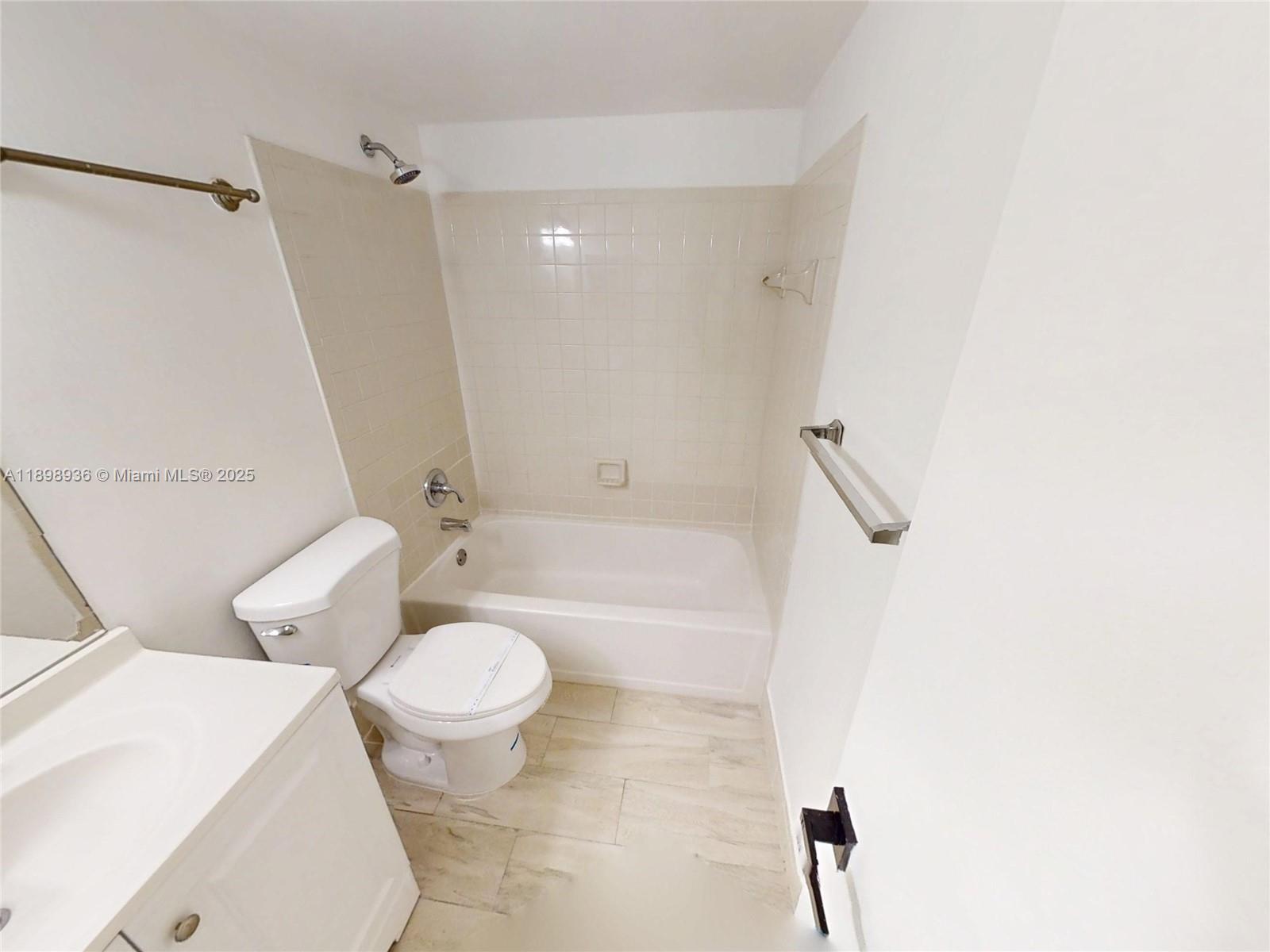 20230 Northeast 3rd Court, Unit 6 Miami, FL 33179 - Photo 25 of 44 a white toilet sitting next to a bath tub