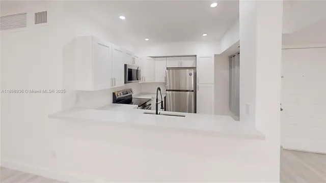 a view of kitchen with refrigerator and chairs