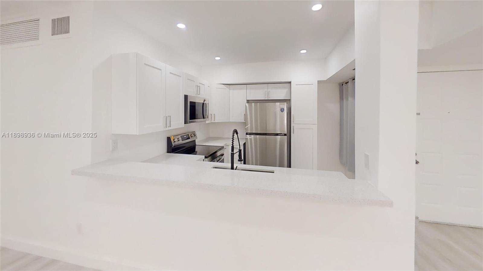 20230 Northeast 3rd Court, Unit 6 Miami, FL 33179 - Photo 3 of 44 a view of kitchen with refrigerator and chairs