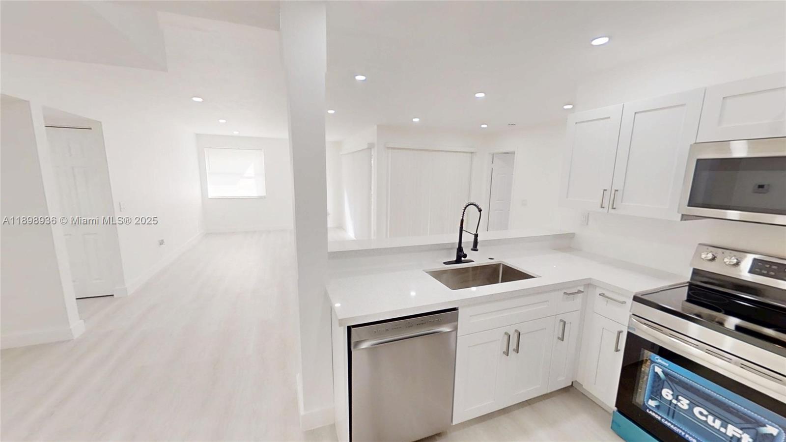 20230 Northeast 3rd Court, Unit 6 Miami, FL 33179 - Photo 7 of 44 a kitchen with a sink white cabinets and stainless steel appliances