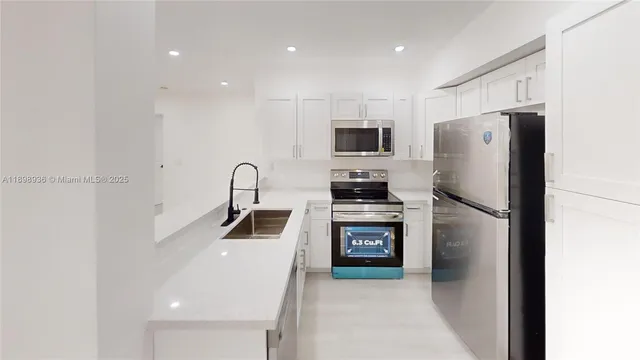 a kitchen with stainless steel appliances a refrigerator sink and microwave