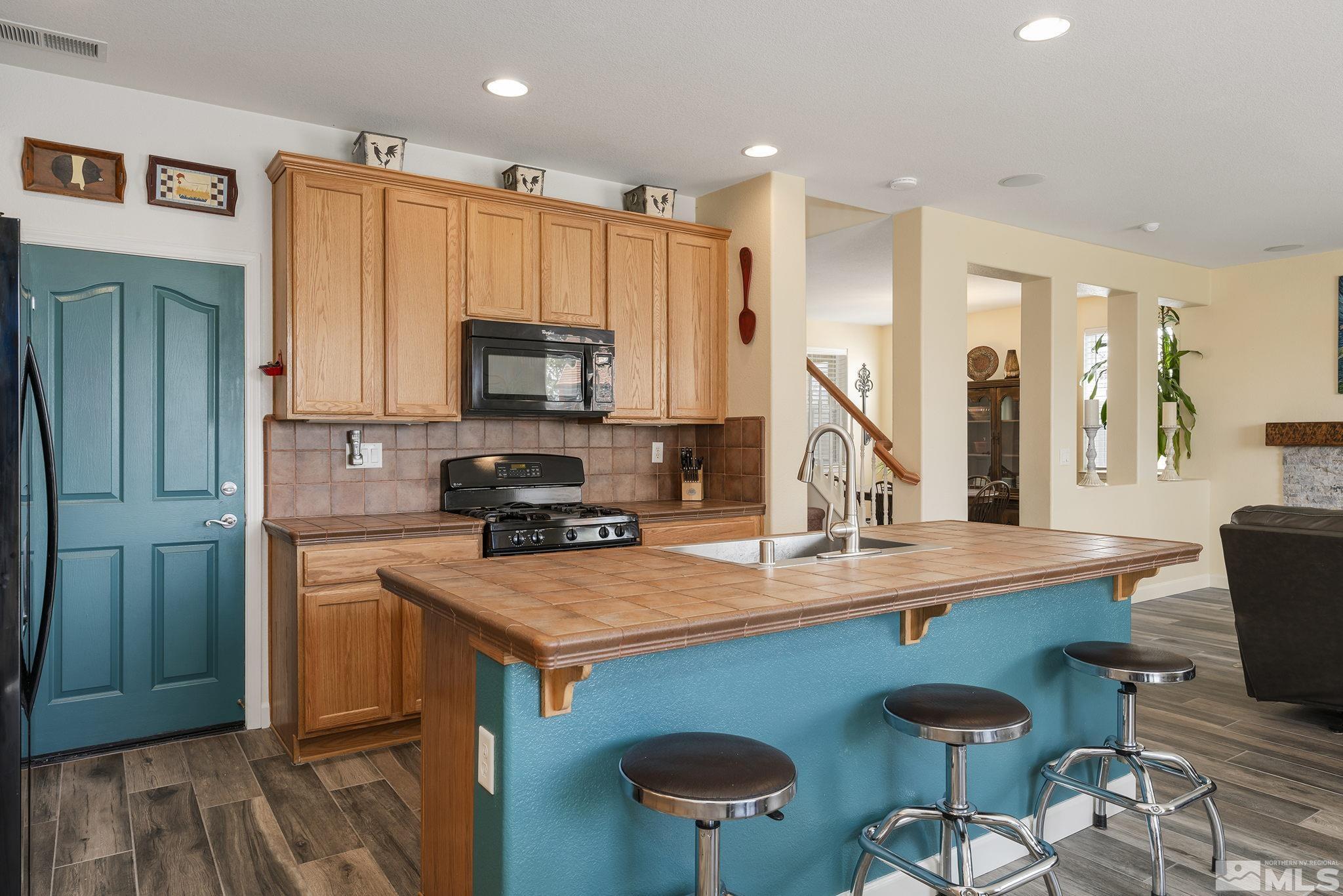 8065 Fire Opal Lane Reno, NV 89506 - Photo 16 of 31 a kitchen with stainless steel appliances granite countertop a stove refrigerator sink and cabinets