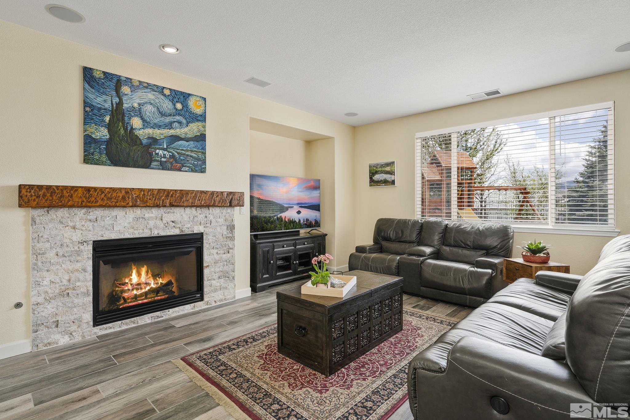 8065 Fire Opal Lane Reno, NV 89506 - Photo 2 of 31 a living room with furniture a large window and a fireplace