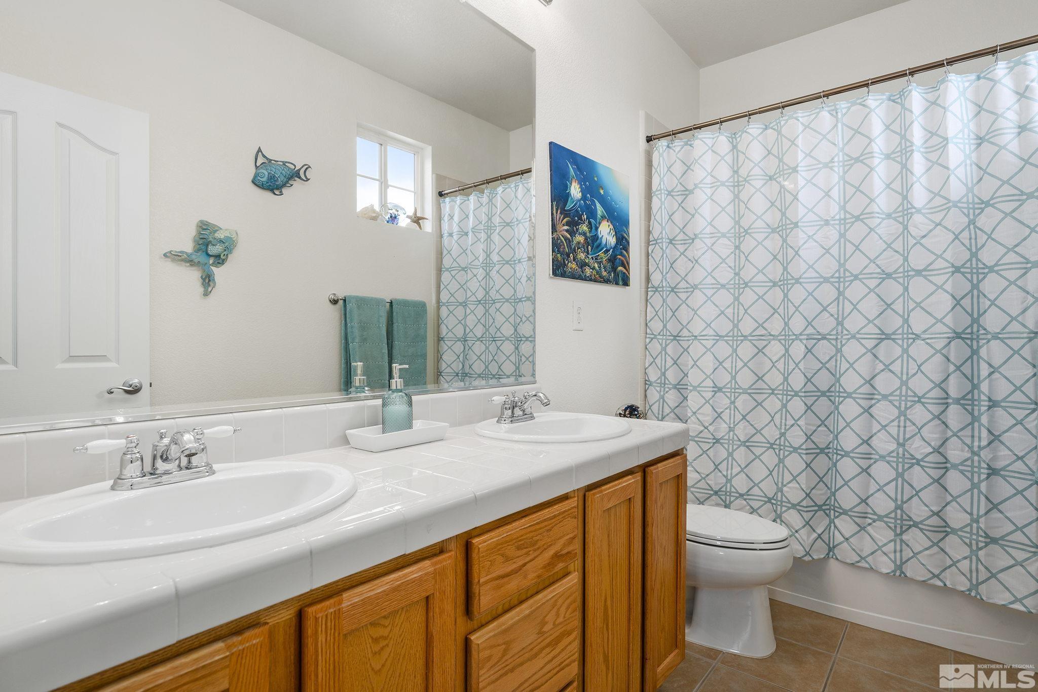8065 Fire Opal Lane Reno, NV 89506 - Photo 24 of 31 a bathroom with a granite countertop sink and a mirror