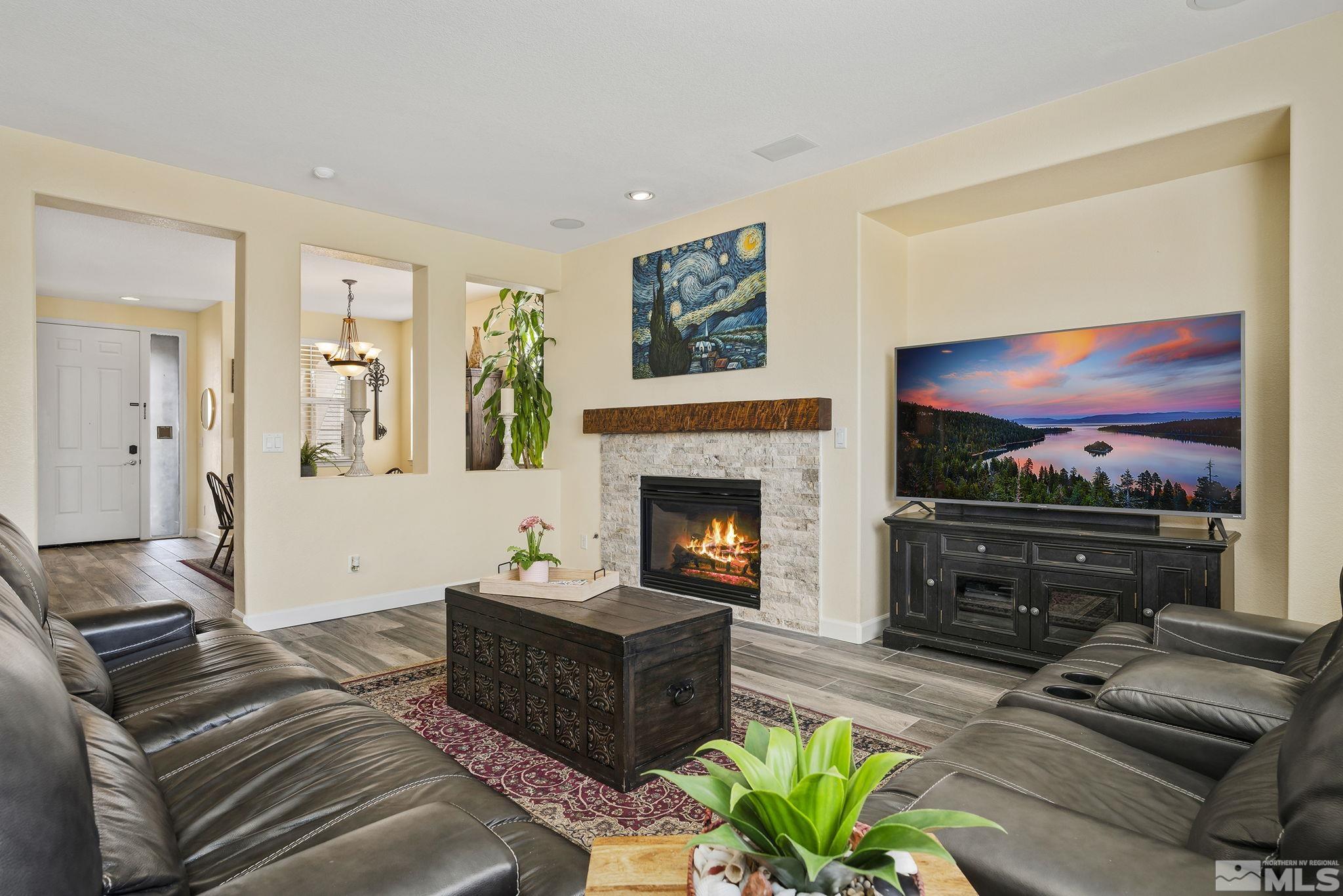 8065 Fire Opal Lane Reno, NV 89506 - Photo 3 of 31 a living room with furniture a flat screen tv and a fireplace