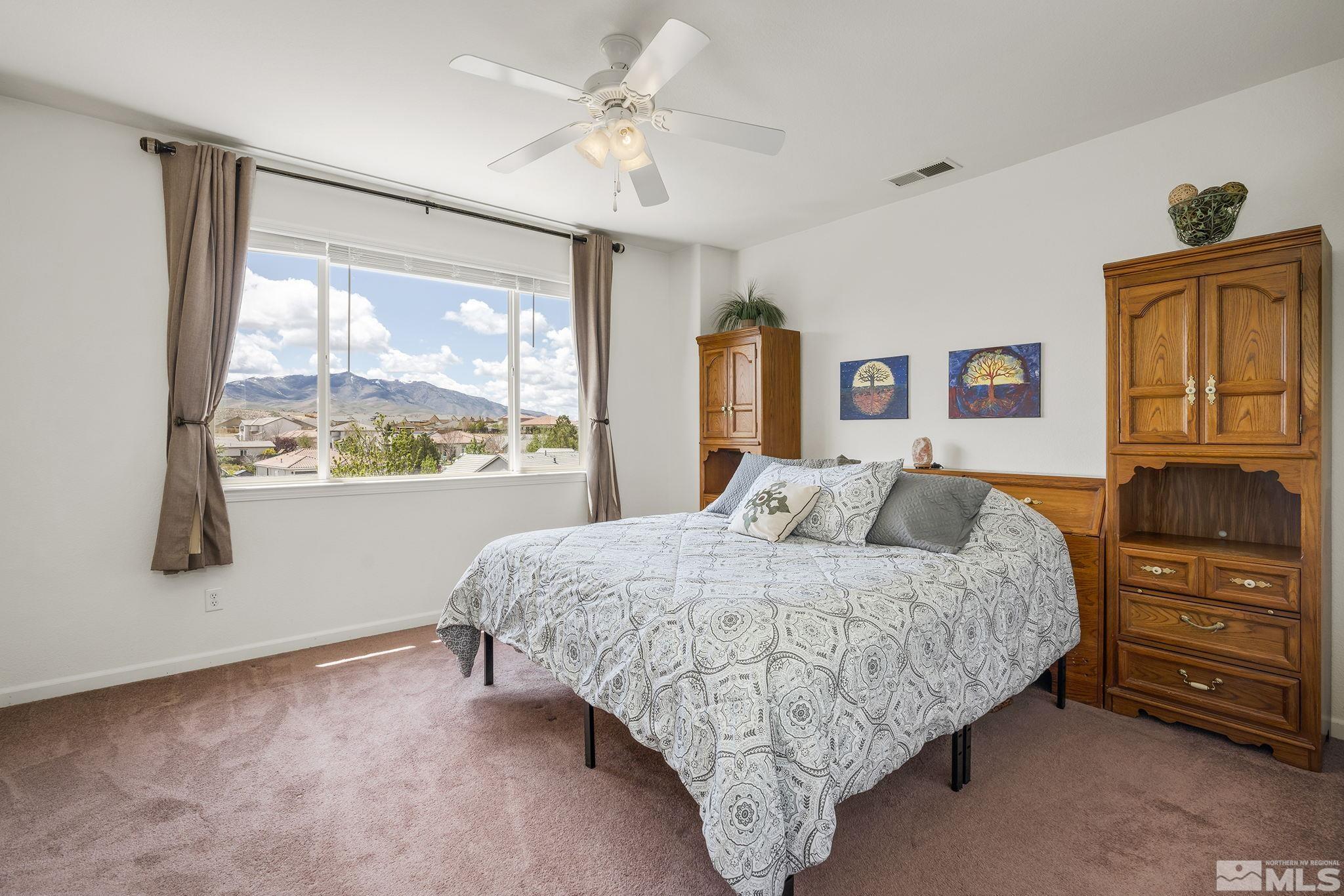 8065 Fire Opal Lane Reno, NV 89506 - Photo 9 of 31 a bedroom with a large bed and dresser with mirror