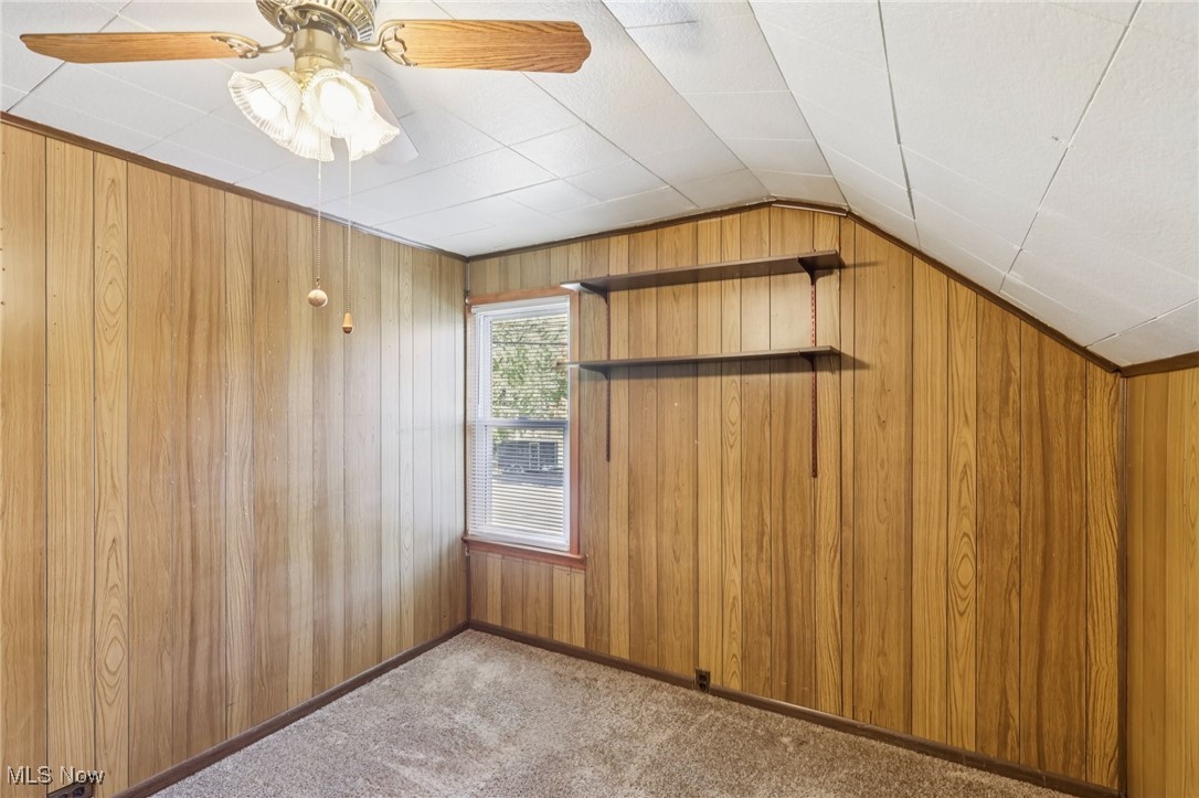 6235 Jefferson Road Ashtabula, OH 44004 - Photo 22 of 40 Additional living space featuring carpet floors, wood walls, ceiling fan, and lofted ceiling