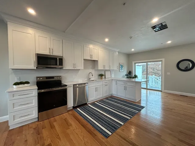 a kitchen with wooden floors appliances and cabinets
