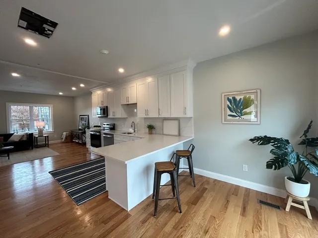 a large kitchen with sink dining table and chairs