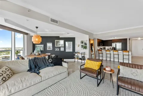 a view of living room kitchen with stainless steel appliances granite countertop a stove and a sink