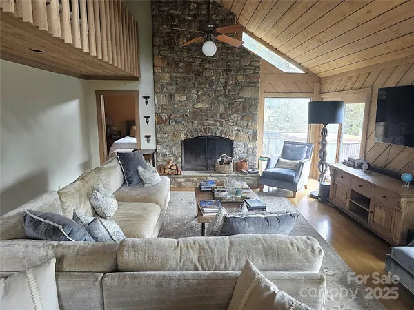 a living room with furniture a fireplace and a flat screen tv