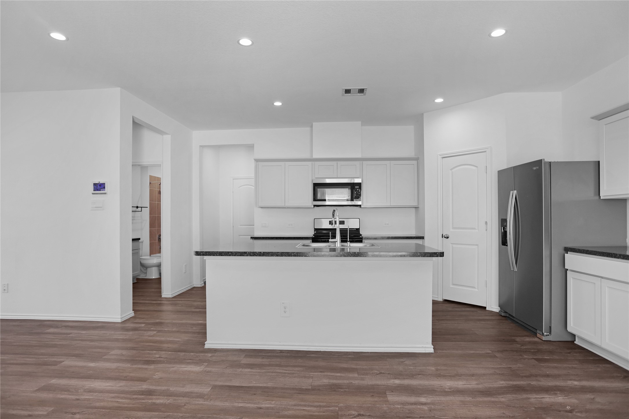 24311 Saddlestone Green Dr Spring Spring, TX 77373 - Photo 12 of 36 a kitchen with stainless steel appliances granite countertop a refrigerator a stove and a wooden floors